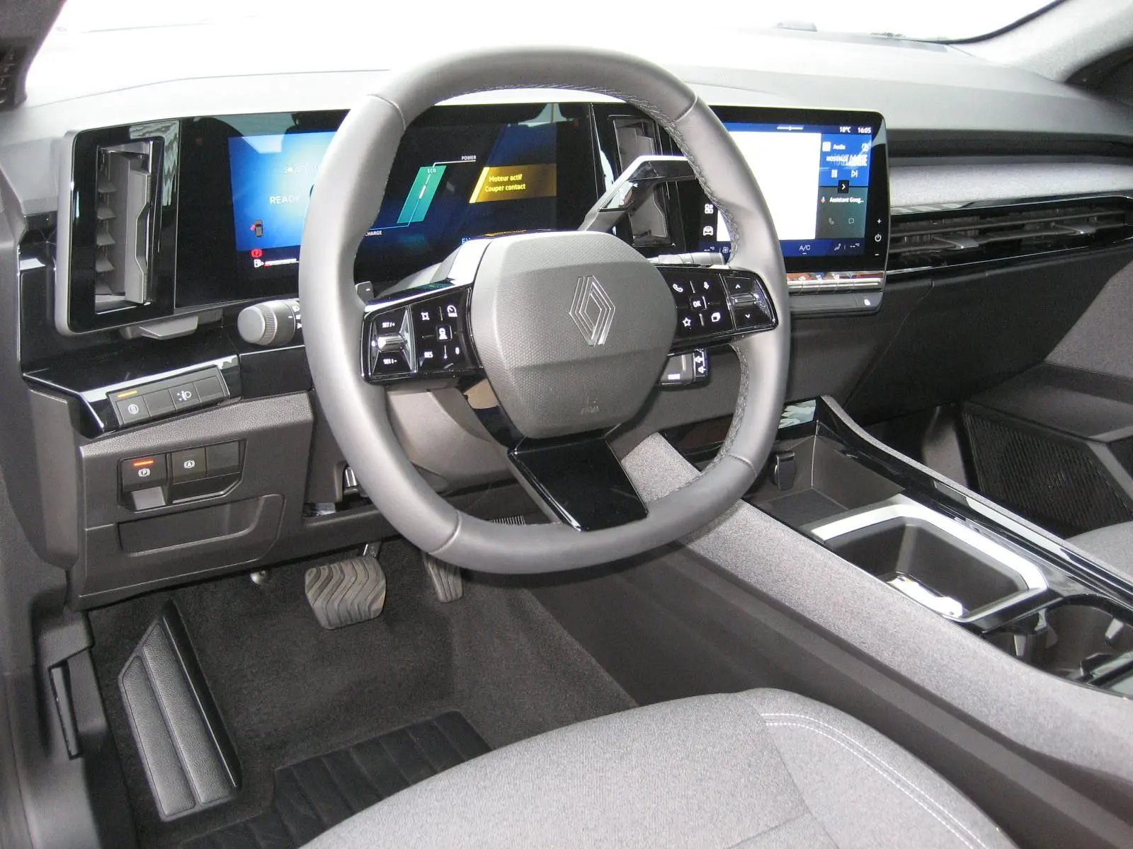 Vue intérieure du tableau de bord et volant du Renault Austral 2025, avec écran digital et finitions modernes grises.