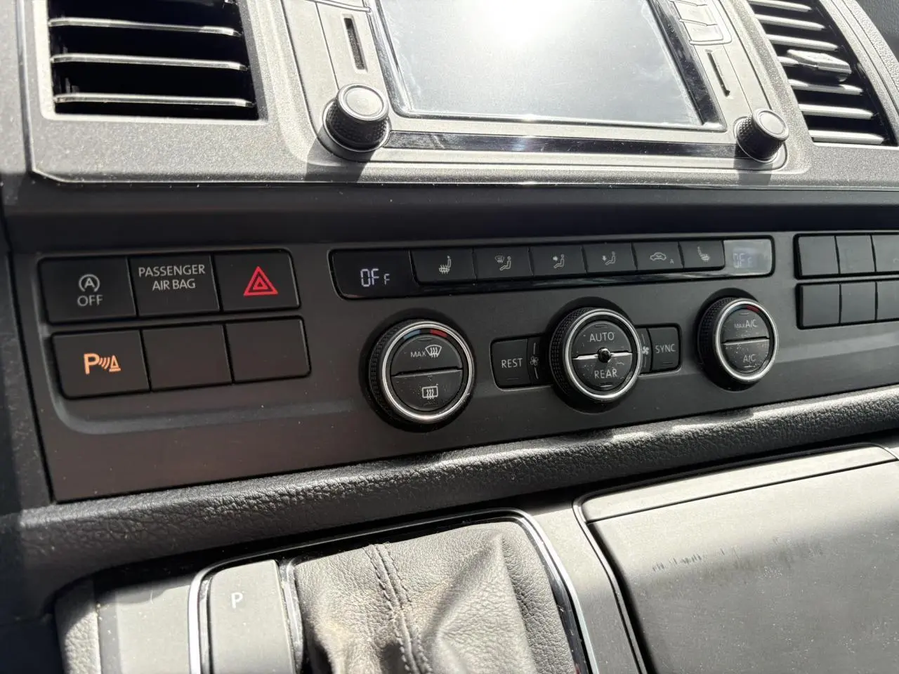 Vue rapprochée du tableau de bord et commandes de climatisation du Volkswagen Multivan T6 gris Indium de 2019.