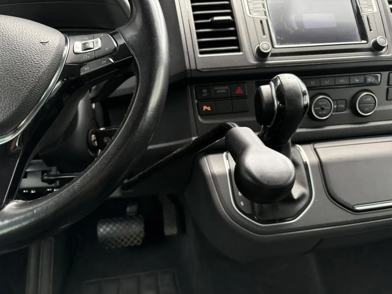 Vue rapprochée de l'intérieur du Volkswagen Multivan T6 2019, montrant le volant cuir et la commande de boîte automatique avec adaptation TPMR.
