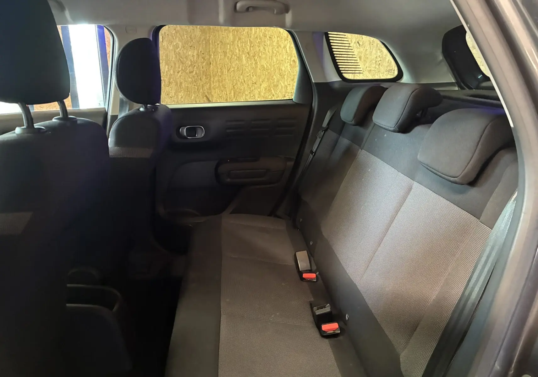 Vue intérieure arrière droite du Citroën C3 Aircross 2023 montrant les sièges arrière en tissu gris noir.
