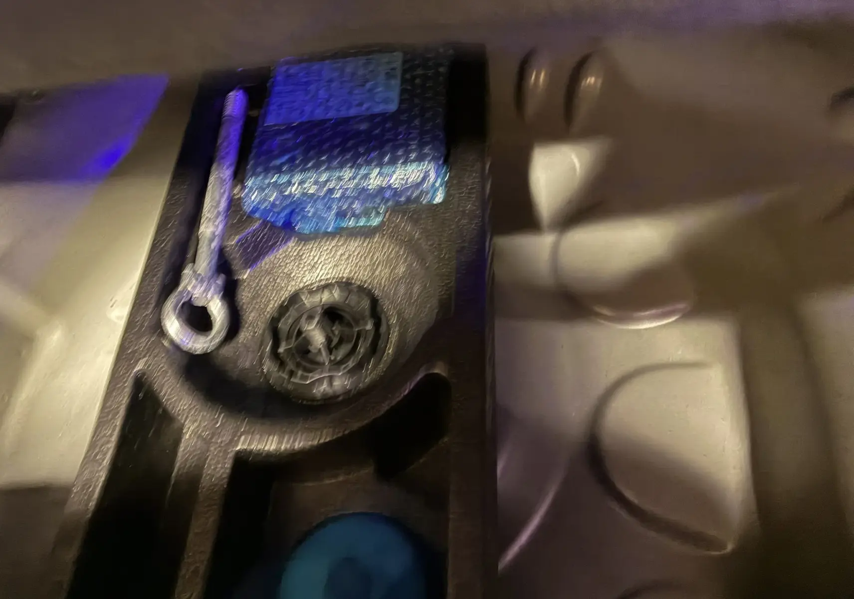 Gros plan sur l'outillage de bord dans le coffre du Citroën C3 Aircross gris platinium, montrant la clé de remorquage et le compresseur.