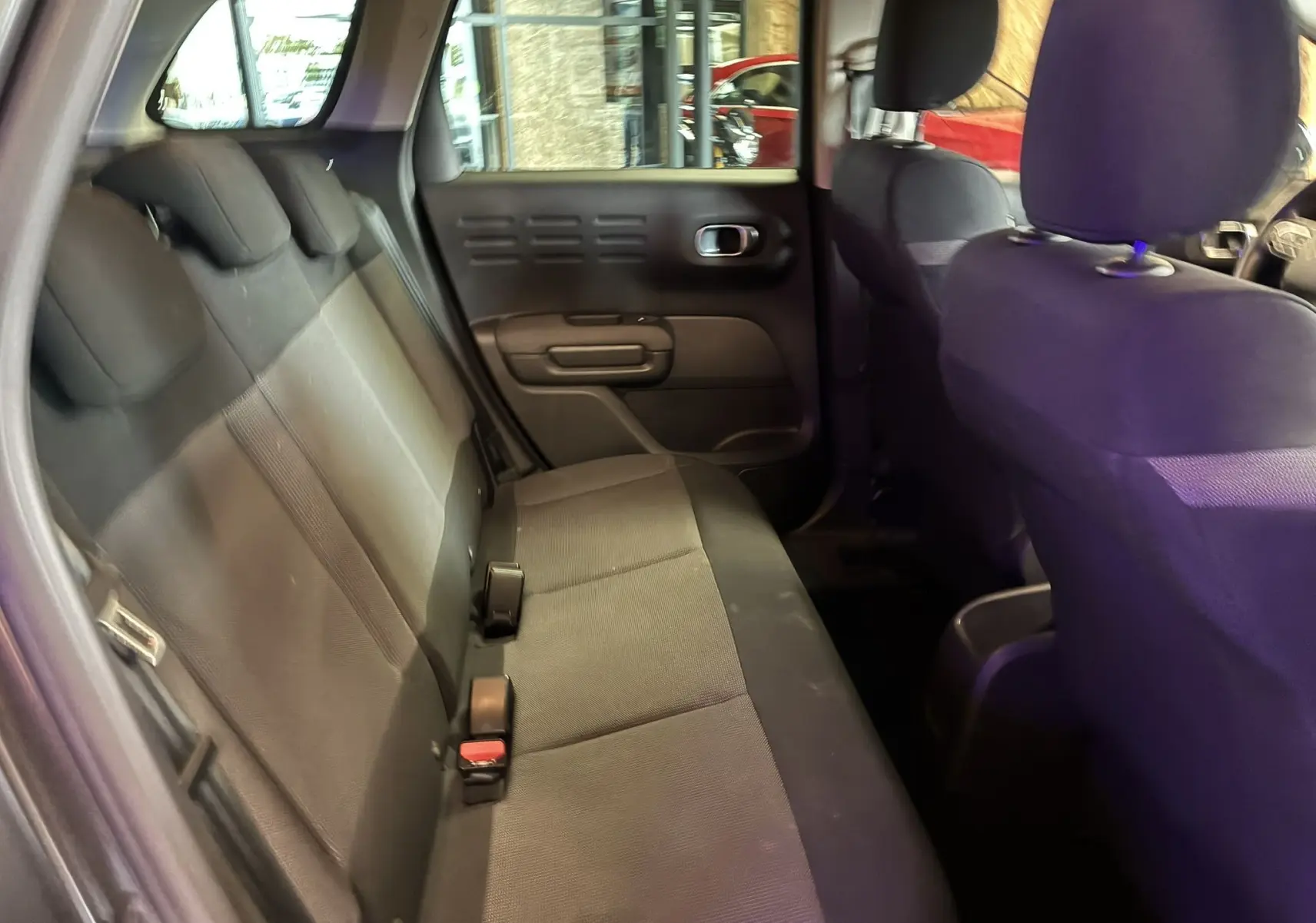 Vue intérieure de la banquette arrière en tissu gris noir du Citroën C3 Aircross 2023, côté gauche ouvert.
