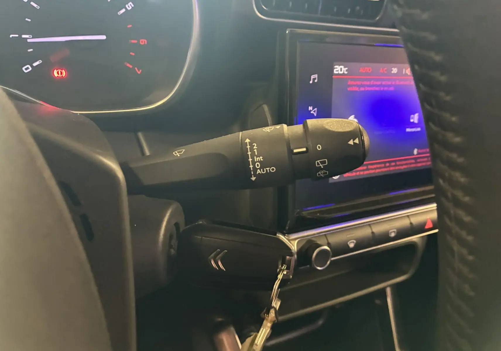 Gros plan sur la commande d'essuie-glace et le tableau de bord tactile du Citroën C3 Aircross 2023 intérieur noir.