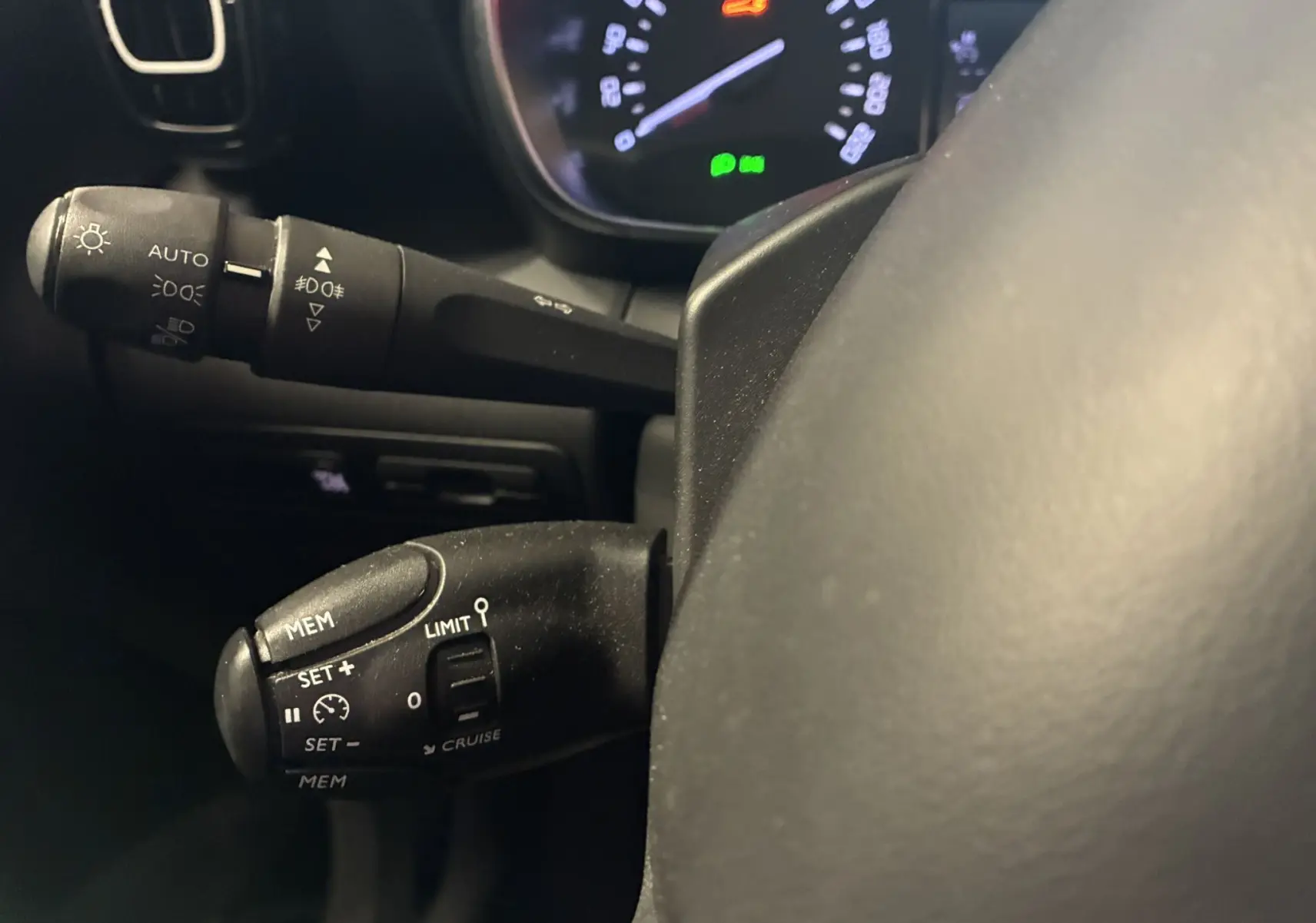 Gros plan sur les commandes au volant du Citroën C3 Aircross 1.5 BlueHDi 110 Shine, tableau de bord en arrière-plan.