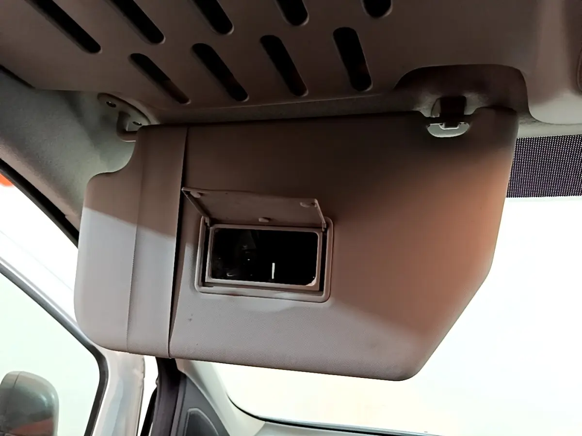 Détail du pare-soleil côté conducteur avec miroir intégré dans l'habitacle du Ford Transit Fourgon blanc.