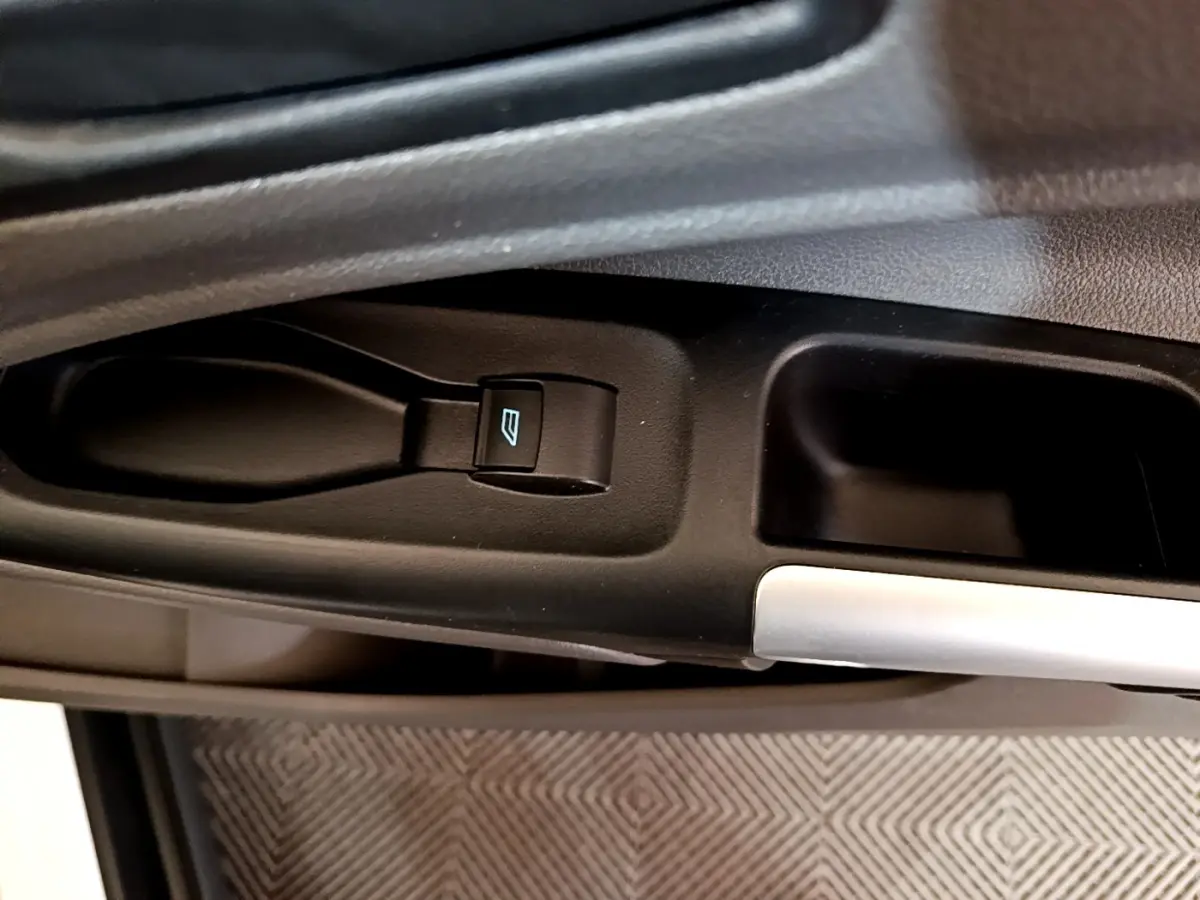 Gros plan sur le bouton de commande de la vitre électrique côté conducteur du Ford Transit Fourgon blanc.