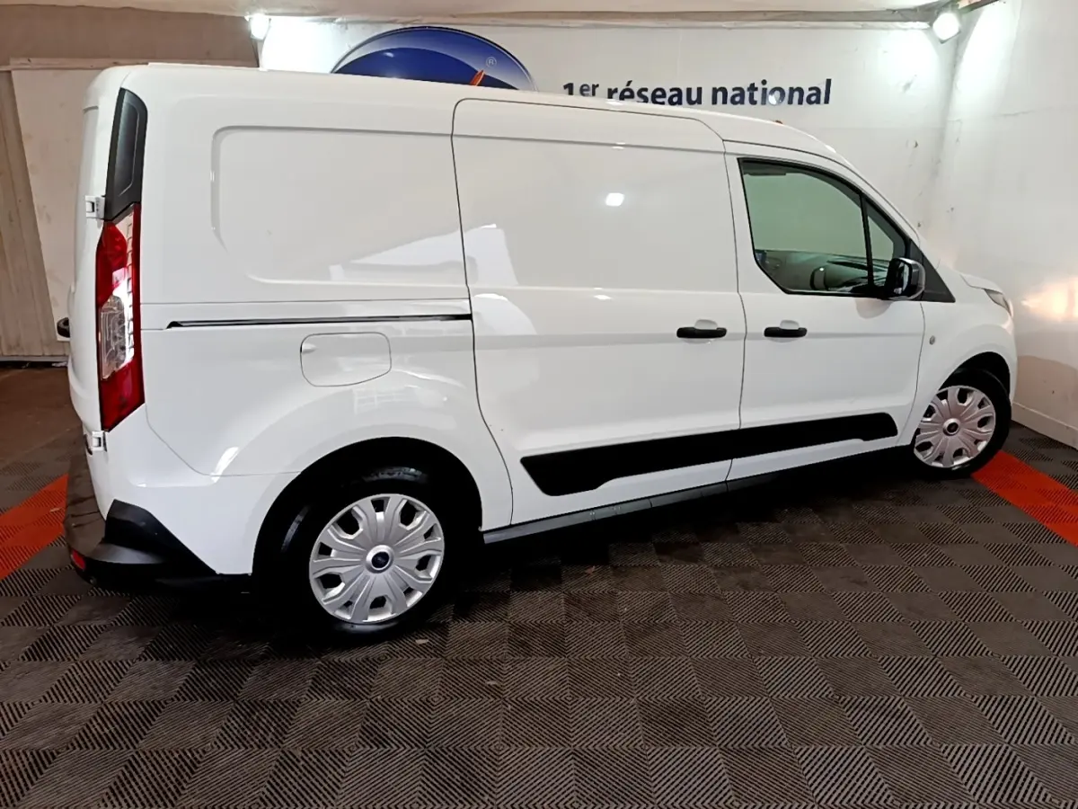 Vue de profil côté droit d'un fourgon Ford Transit blanc, avec jantes argentées et poignées noires.