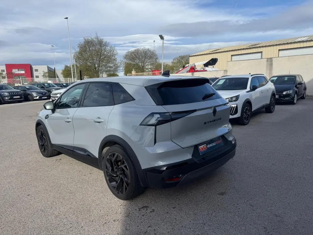 Vue 3/4 arrière droite d'un Renault SYMBIOZ gris clair avec jantes alliage noires et vitres teintées.