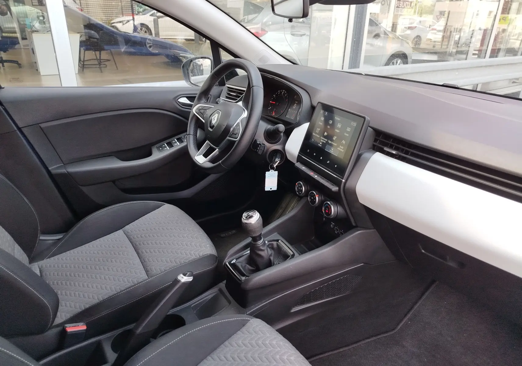 Vue intérieure côté conducteur de la Renault Clio 1.0 SCe 65ch Evolution 2022, avec tableau de bord moderne et écran tactile central.