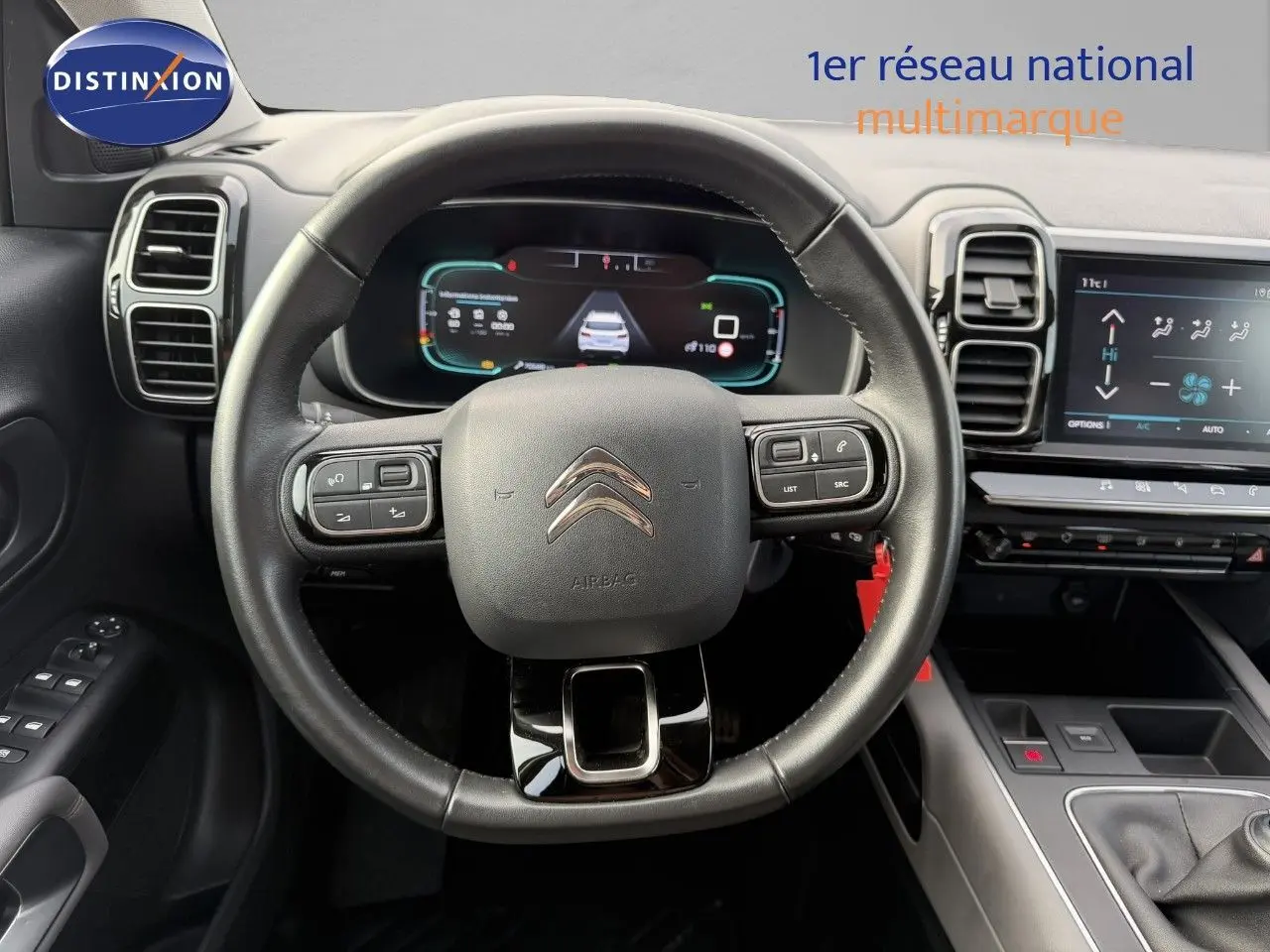 Vue frontale du volant en cuir noir et du tableau de bord numérique du Citroën C5 Aircross blanc nacré de 2019.