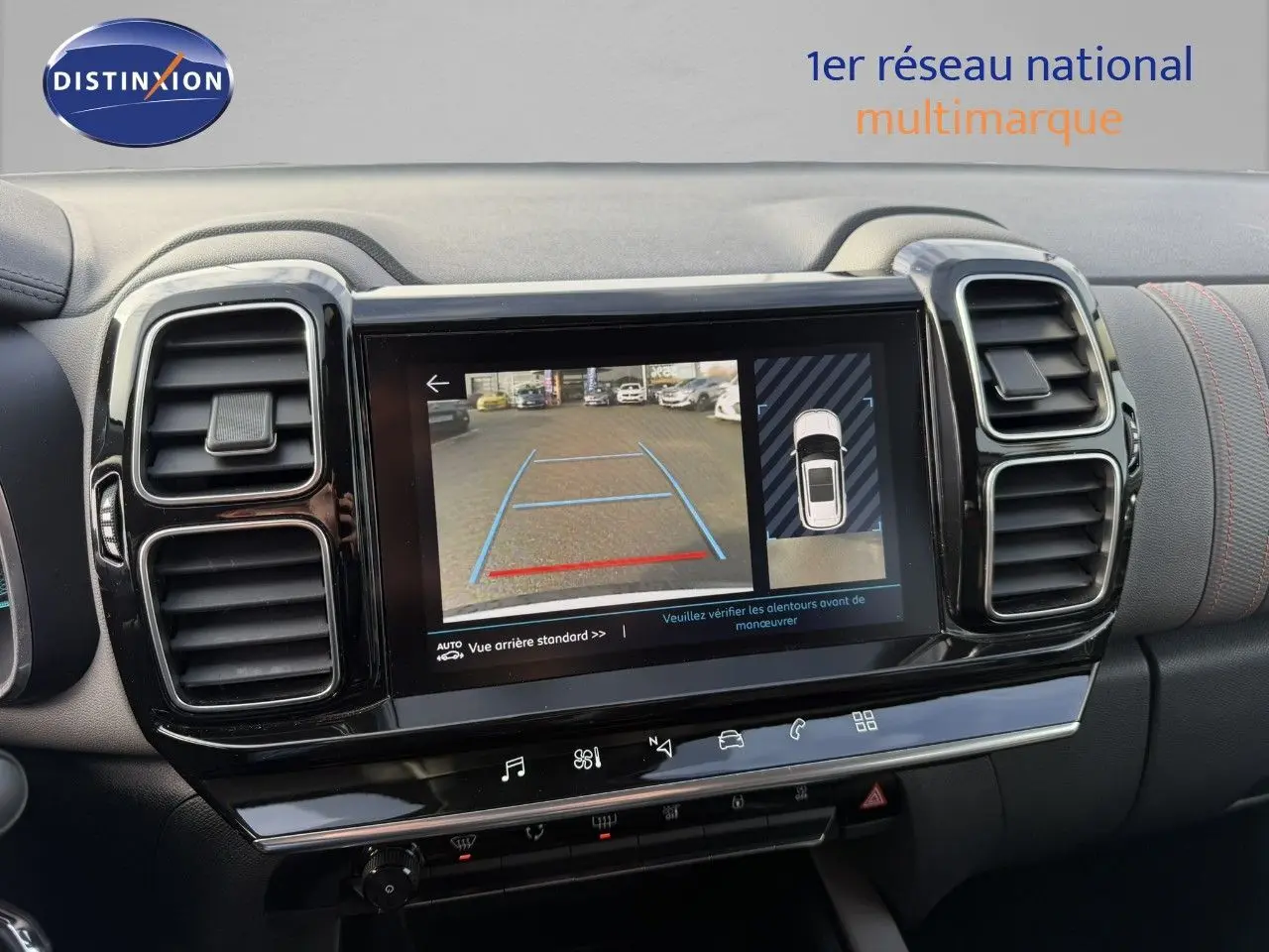 Vue rapprochée de l'écran multimédia affichant la caméra de recul dans l'habitacle noir du Citroën C5 Aircross blanc nacré.