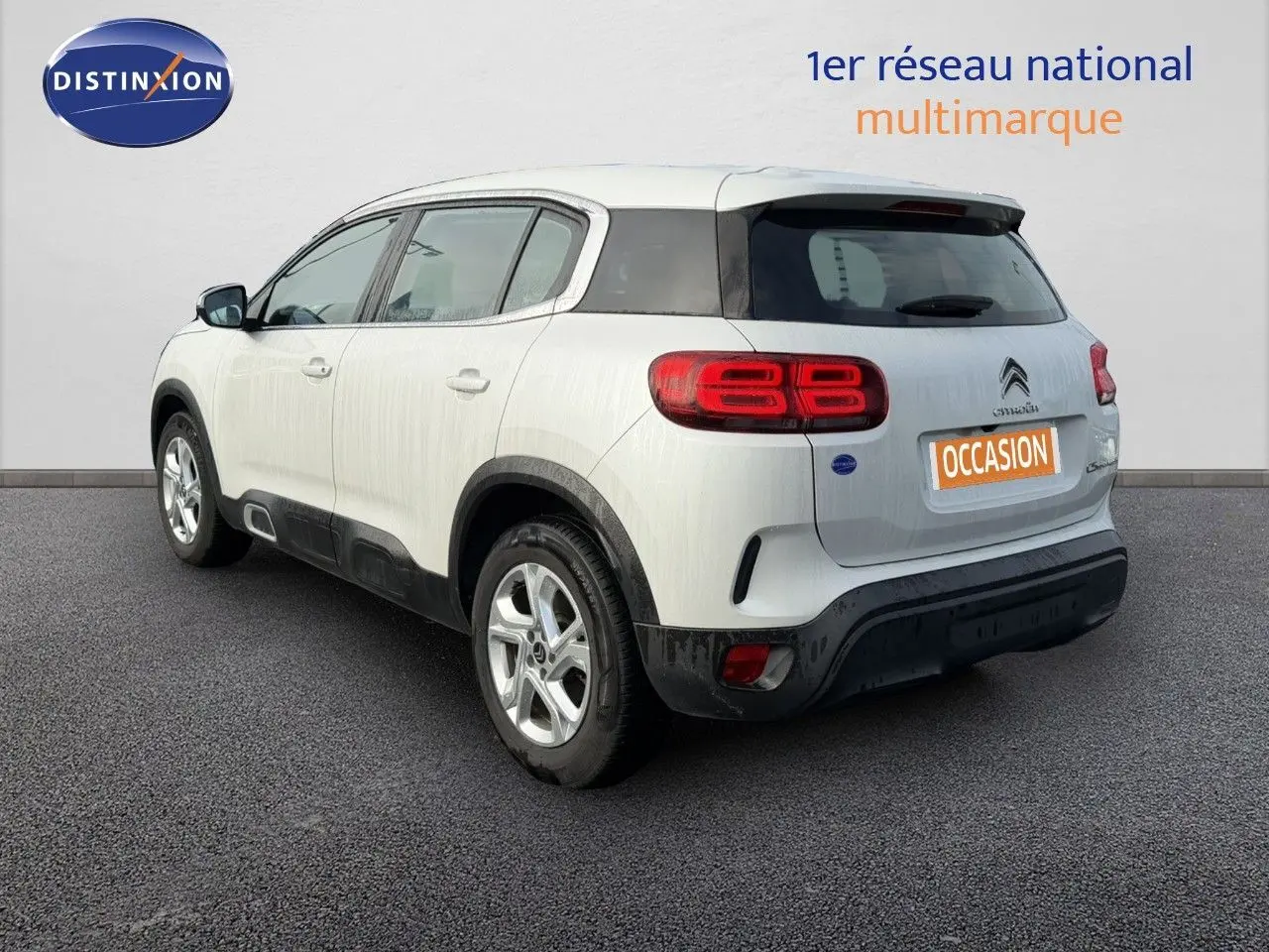 Vue 3/4 arrière droite du Citroën C5 Aircross blanc nacré avec feux arrière distinctifs et jantes alliage.