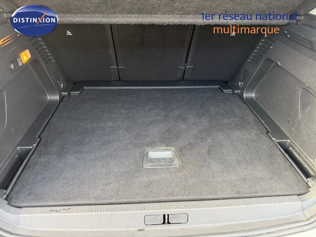 Coffre spacieux vu de face, intérieur noir avec tapis de sol et rangements latéraux du Citroën C5 Aircross blanc nacré.