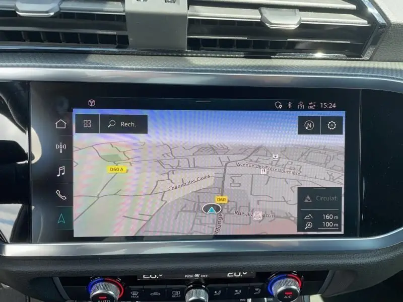 Écran tactile du système de navigation d'un Audi Q3 blanc 2021, affichant une carte routière détaillée.