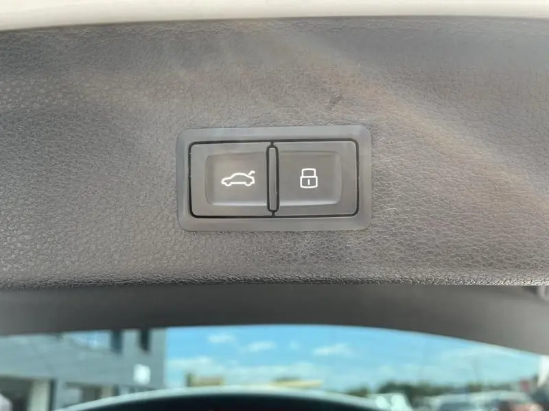 Boutons d'ouverture du coffre et de verrouillage intégrés dans le panneau intérieur du hayon d'un Audi Q3 blanc 2021.