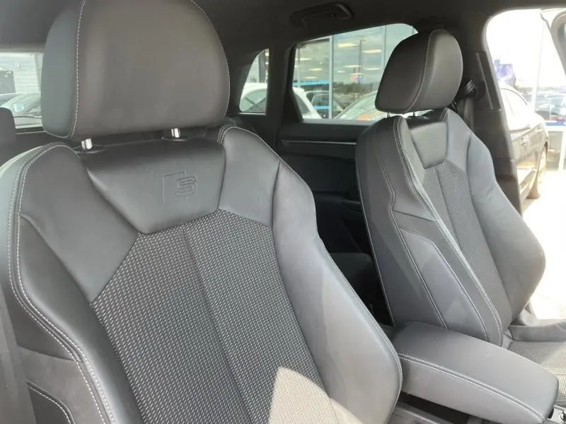 Gros plan sur les sièges avant sport en cuir noir embossés du logo S de l'Audi Q3 35 TFSI S-Line 2021.