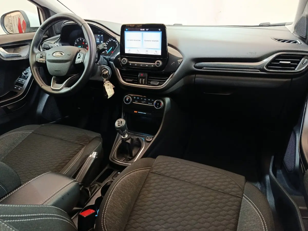 Intérieur de la Ford Puma 2022 vu côté conducteur, tableau de bord noir avec écran tactile central et boîte manuelle.