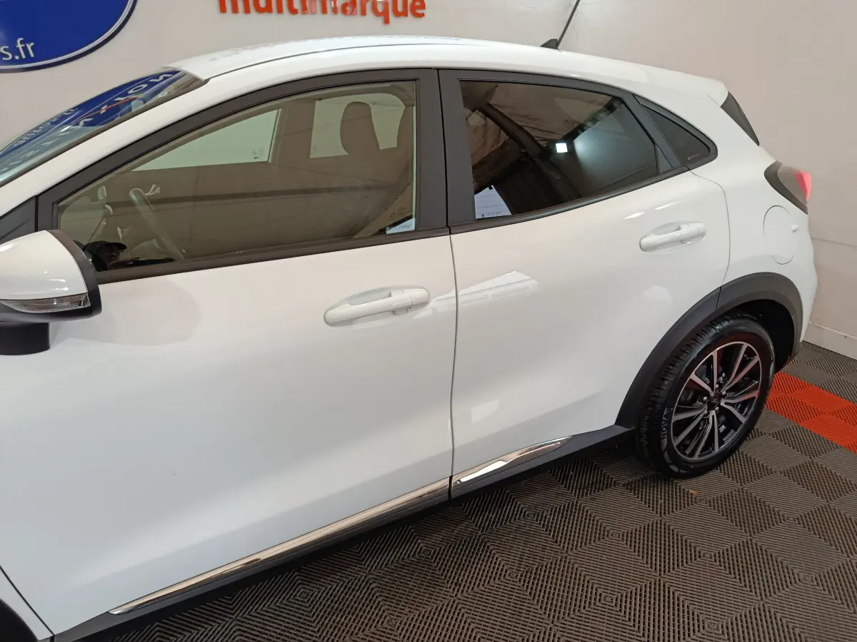Vue latérale droite du Ford Puma blanc 2022, mettant en valeur les jantes alliage et les contours chromés.