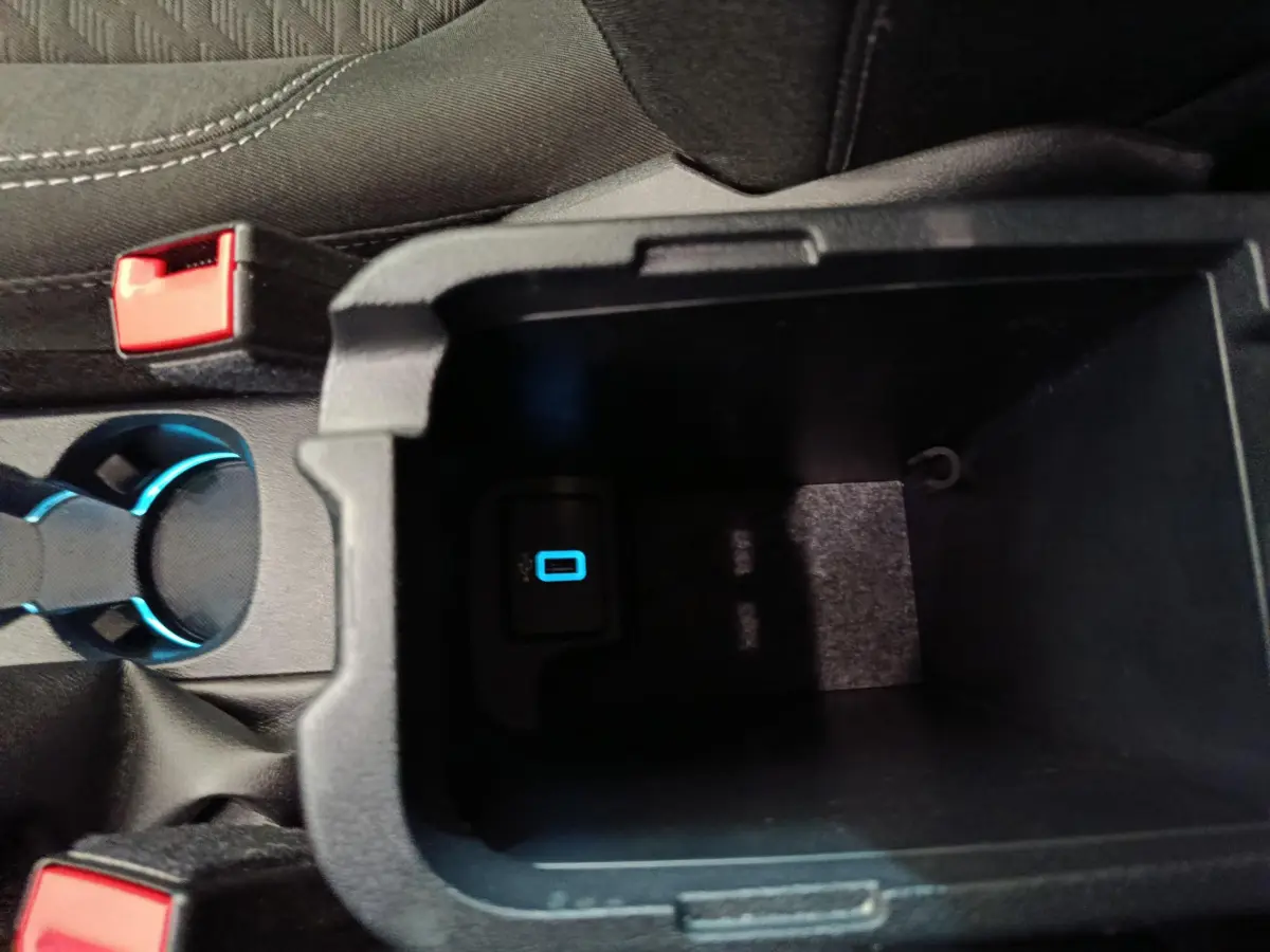 Vue rapprochée de la console centrale noire du Ford Puma 2022 montrant un port USB éclairé en bleu.