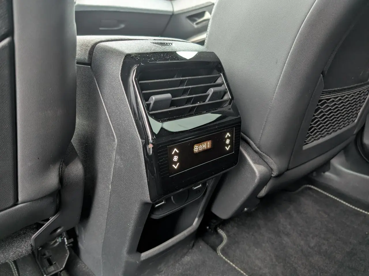Détail de la console centrale arrière avec commandes de climatisation et prises USB dans l’habitacle noir du Peugeot 5008 gris.