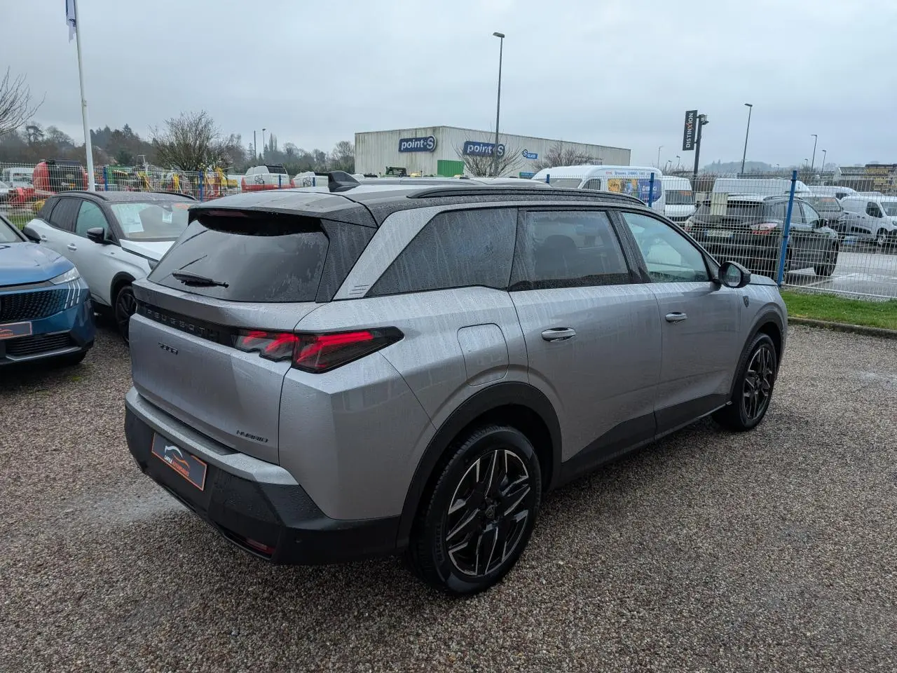 Vue 3/4 arrière droite du Peugeot 5008 gris métallisé 2025 avec feux arrière à LED 3 griffes et jantes alliage 19 pouces.