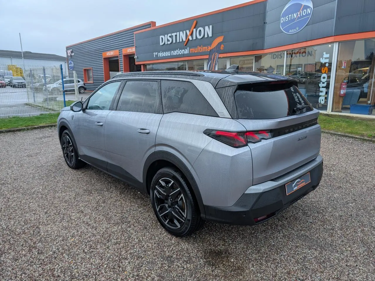 Peugeot 5008 gris métallisé vue 3/4 arrière droit, feux arrière LED 3 griffes et jantes alliage 19 pouces.
