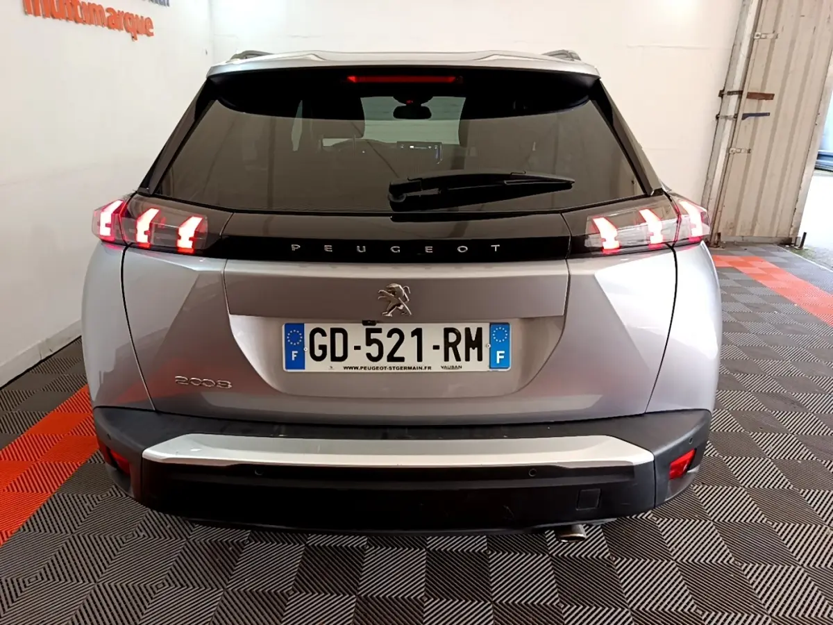 Vue arrière d’un Peugeot 2008 gris clair de 2021 avec feux LED allumés et plaque d’immatriculation française.