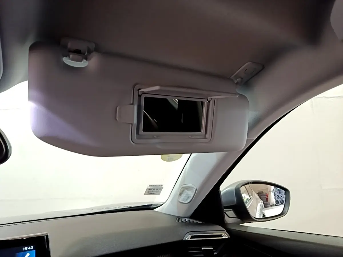Détail intérieur du pare-soleil côté conducteur avec miroir éclairé sur Peugeot 2008 gris clair, vue depuis l’habitacle.