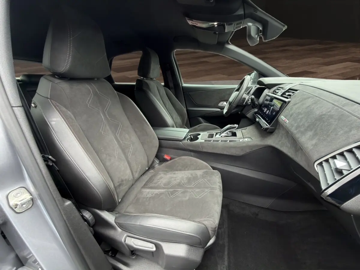 Vue intérieure côté conducteur du DS7 Crossback gris clair, mettant en valeur les sièges en alcantara et le tableau de bord digital.
