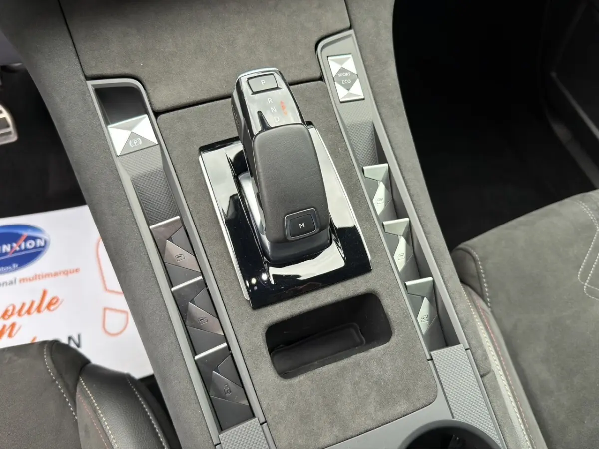 Vue rapprochée de la console centrale grise du DS7 Crossback 2022, avec levier de vitesse automatique et boutons multifonctions.