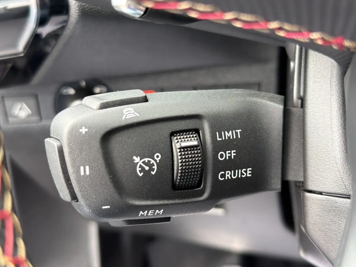 Gros plan sur la commande de régulateur de vitesse au volant cuir du DS7 Crossback gris clair 2022.