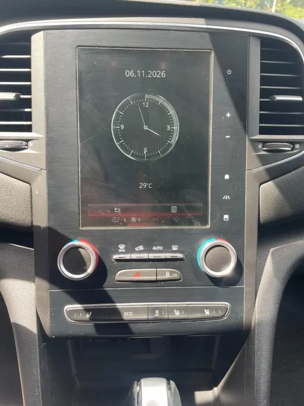 Vue rapprochée de la console centrale de la Renault Mégane IV avec écran tactile, commandes climatisation et boîte auto visible.