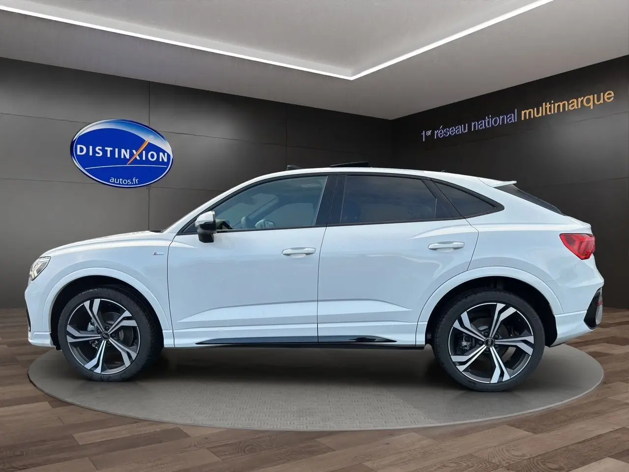 Audi Q3 Sportback blanc vue de profil côté gauche avec jantes sport noires et toit panoramique.