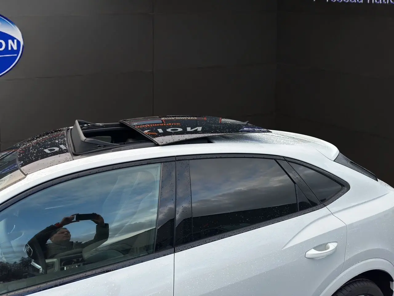 Vue latérale gauche d'un Audi Q3 Sportback blanc avec toit ouvrant panoramique et vitres surteintées.