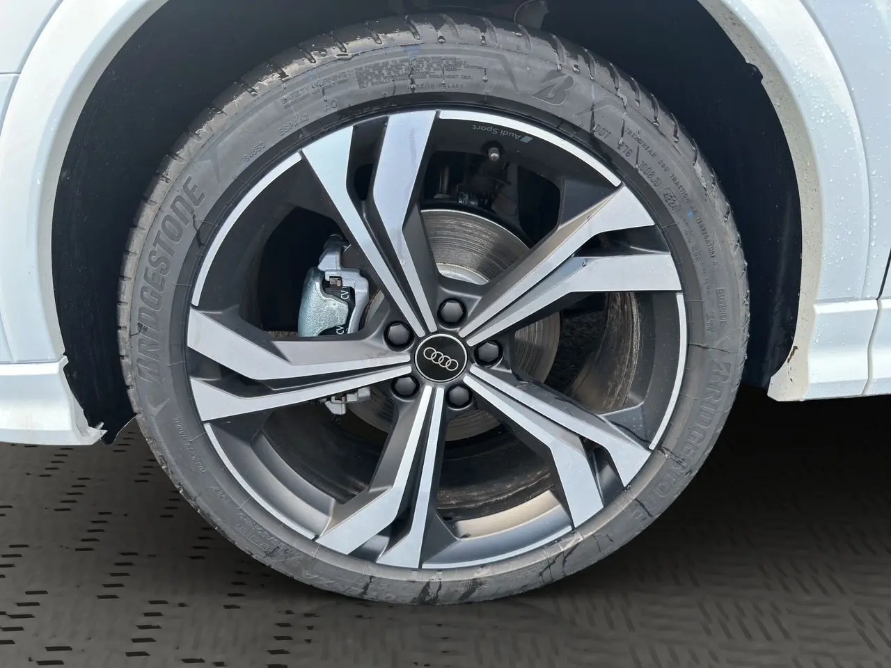 Gros plan sur la jante noire et argent à 5 branches doubles de l'Audi Q3 Sportback blanc glacier.