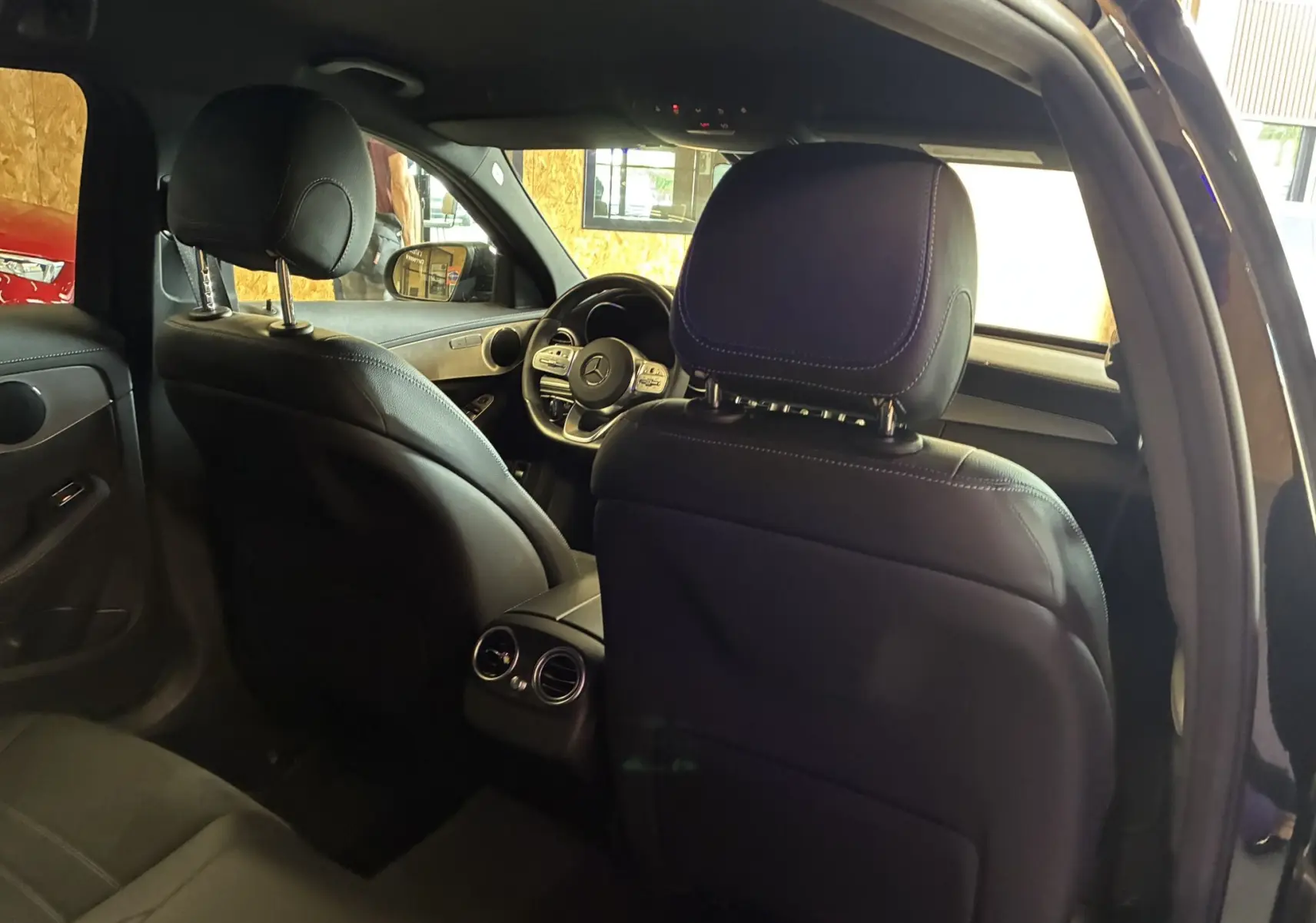 Vue intérieure arrière du Mercedes Classe C Break 220d noir métal, sièges cuir et volant multifonction visibles.