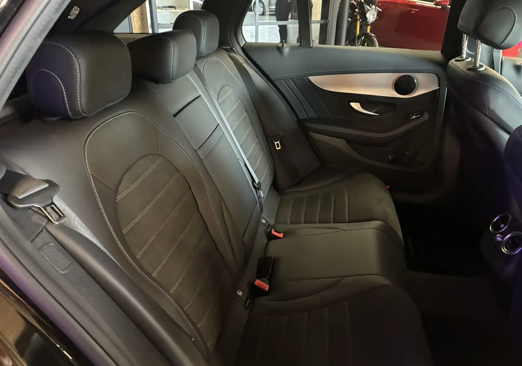 Vue intérieure côté droit des sièges arrière en cuir noir et alcantara d'une Mercedes Classe C Break 220D AMG Line 2021.