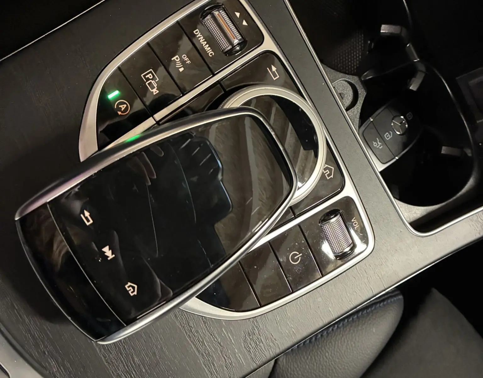 Gros plan sur la console centrale noire mate de la Mercedes Classe C Break 220D AMG Line avec pavé tactile et commandes multimédia.