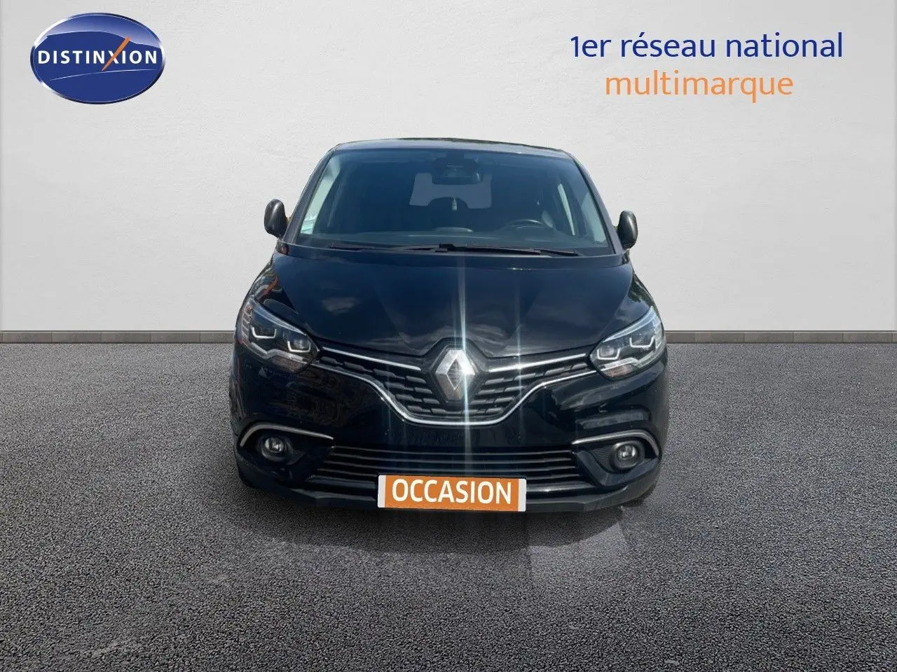 Vue frontale d’un Renault Scénic IV noir 2017 avec calandre chromée et phares LED allumés.