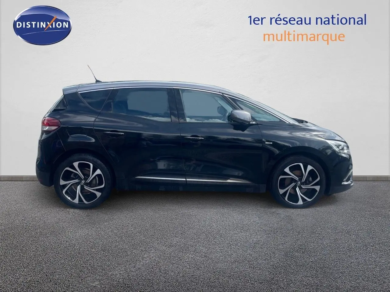 Profil côté gauche d’un Renault Scénic IV noir de 2017 avec jantes alliage au design moderne sur fond neutre.
