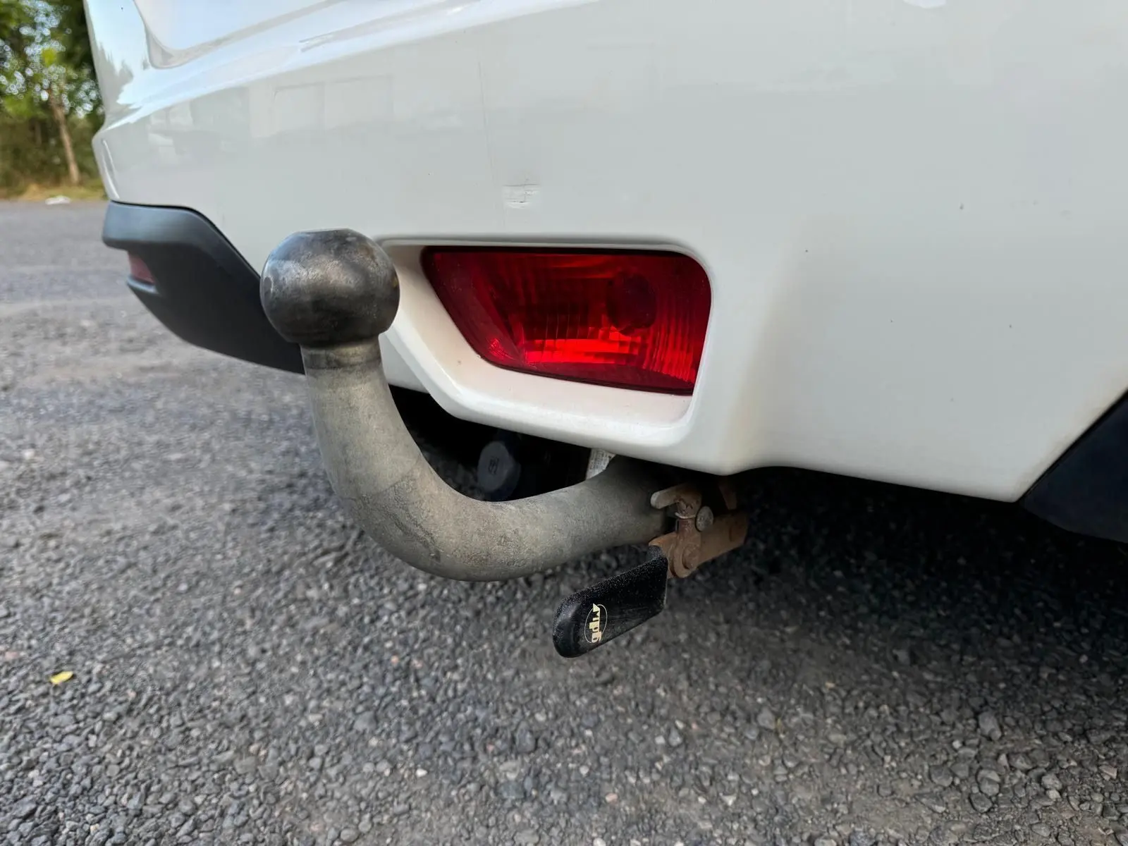 Gros plan sur l'attelage d'une SsangYong Tivoli blanc 2016 avec feu arrière rouge visible sur le côté droit arrière.