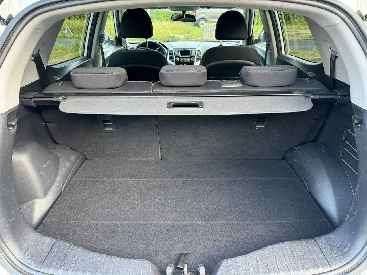 Coffre ouvert du SsangYong Tivoli blanc 2016, vue arrière montrant l'espace de chargement et les sièges arrière rabattus.