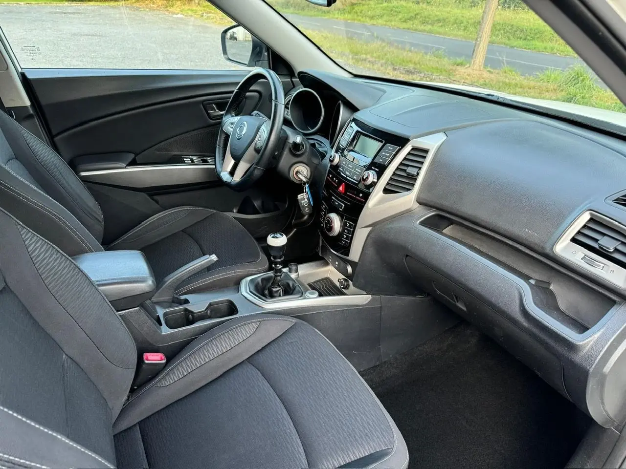 Intérieur noir du Ssangyong Tivoli 2016 vu côté conducteur, avec tableau de bord et levier de vitesse manuel visibles.