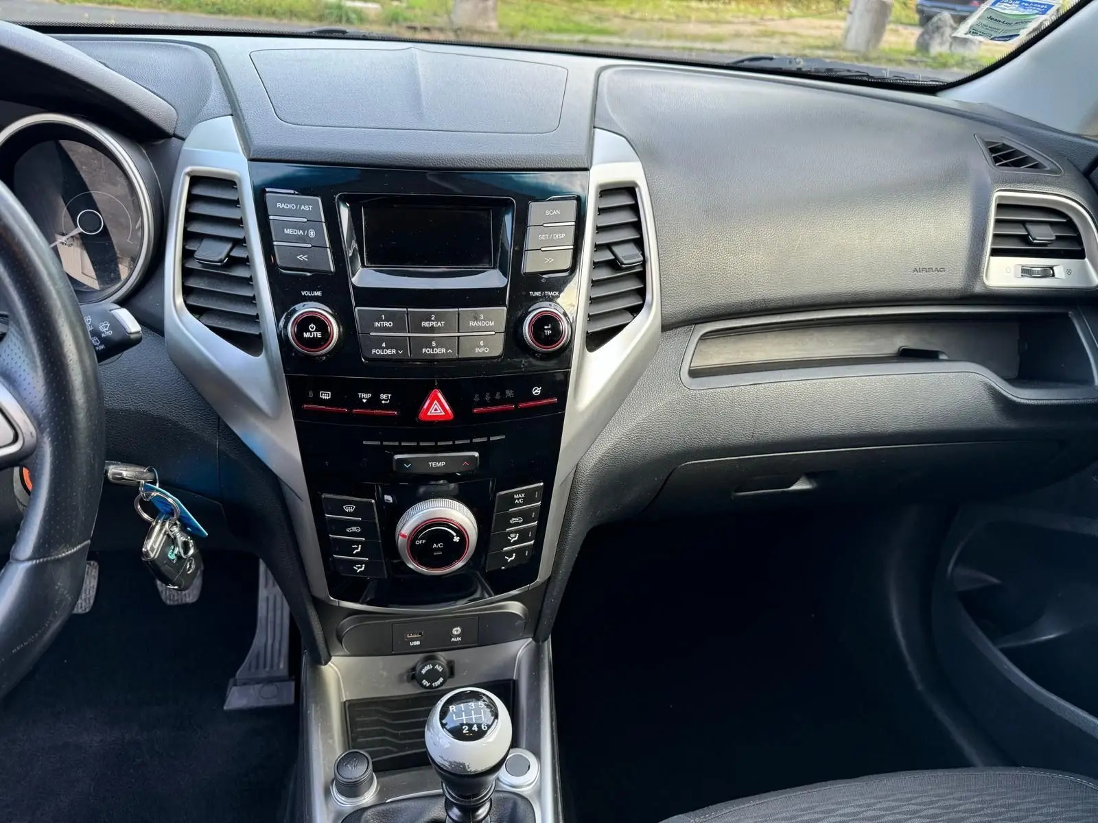 Intérieur du SsangYong Tivoli 2016, vue centrale du tableau de bord avec console noire et levier de vitesse manuel.