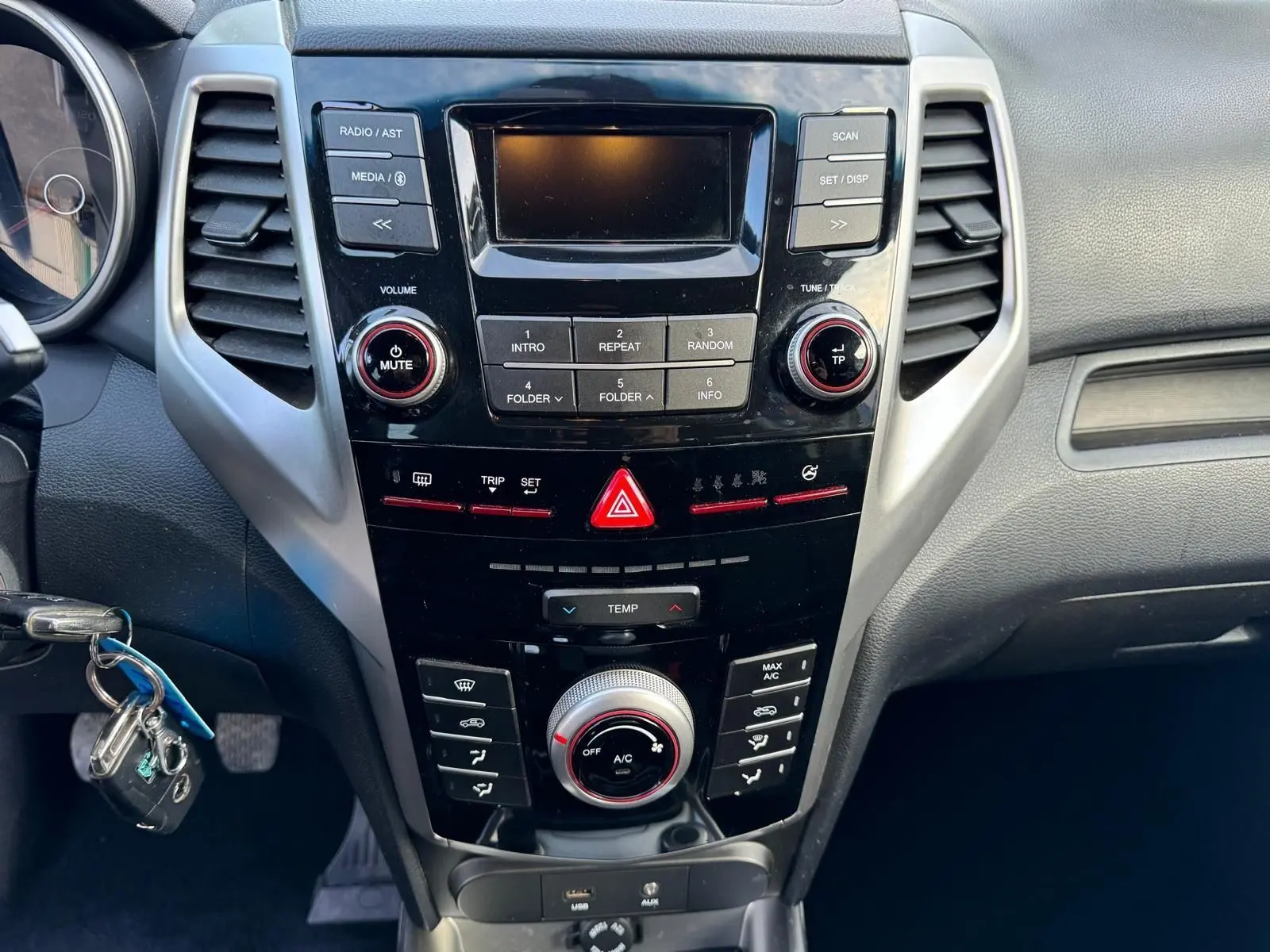 Vue rapprochée du tableau de bord noir du SsangYong Tivoli 2016 avec commandes audio et climatisation.