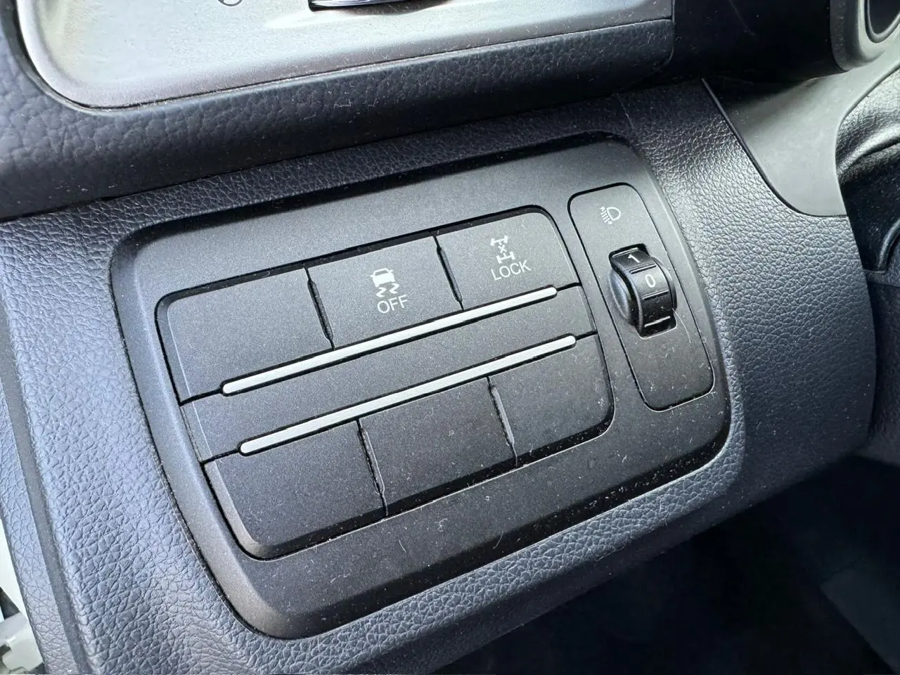 Gros plan sur les commandes de traction et verrouillage 4x4 dans l'habitacle noir du SsangYong Tivoli blanc 2016.