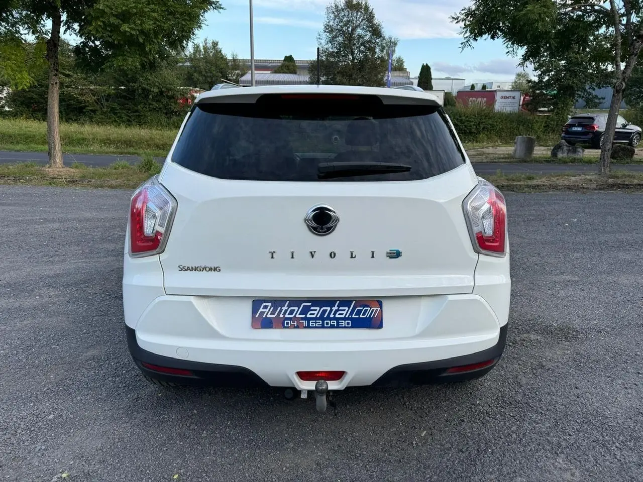Vue arrière d'un SsangYong Tivoli blanc 2016 avec attelage visible sur un parking extérieur.