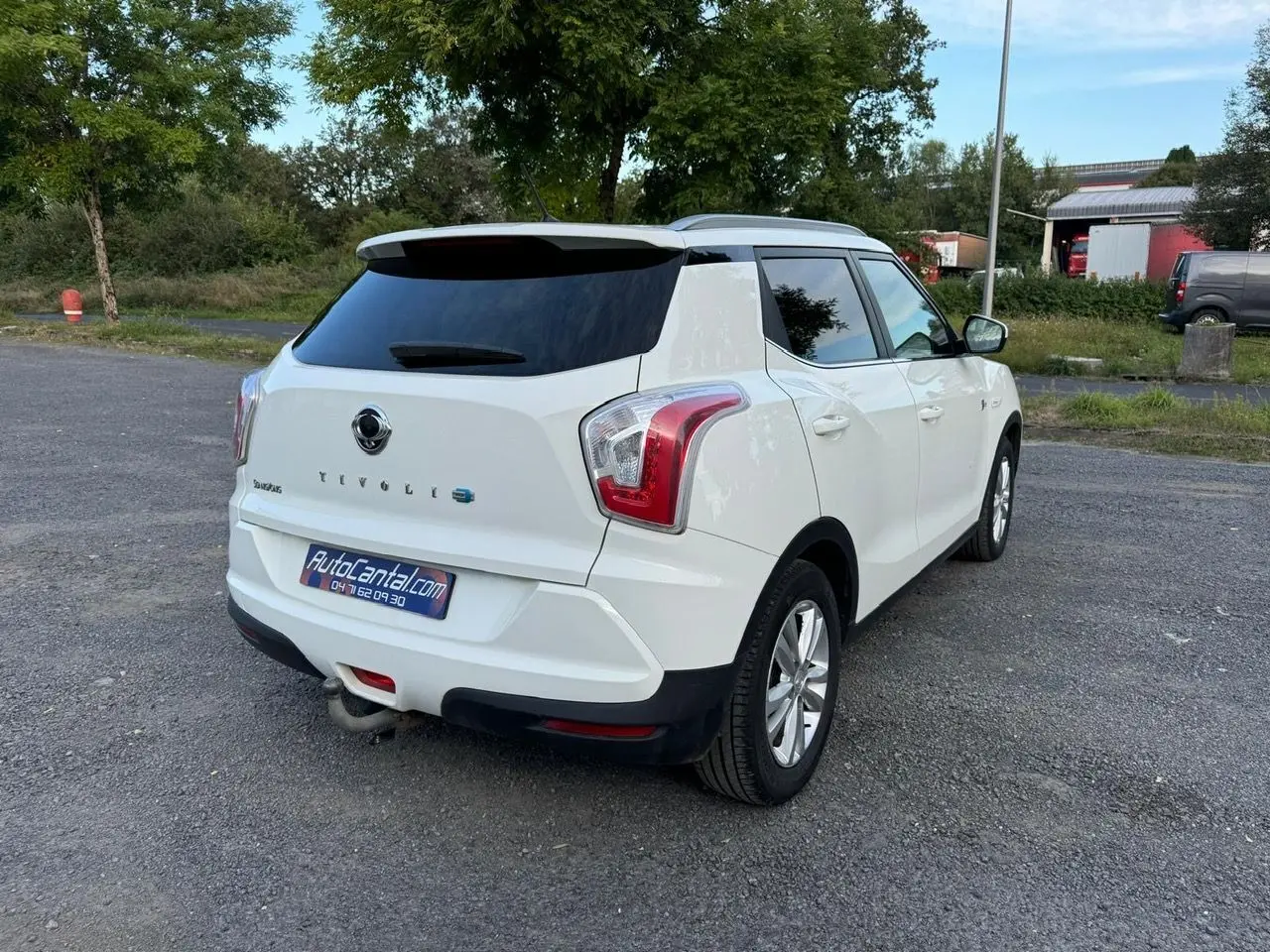 Vue 3/4 arrière droite d'un SsangYong Tivoli blanc 2016 avec attelage et vitres arrière teintées.