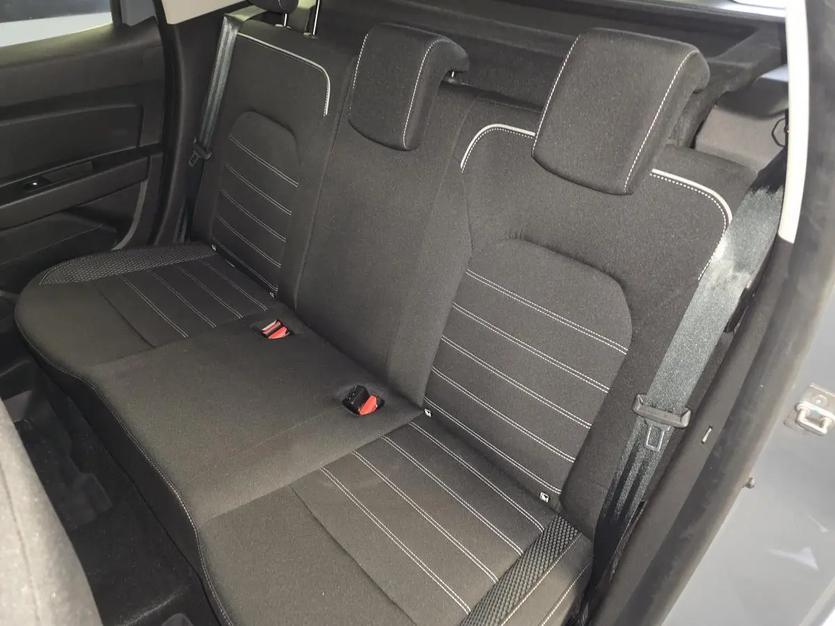 Vue arrière côté droit sur la banquette noire avec surpiqûres blanches du Dacia Duster 2024 gris urbain.