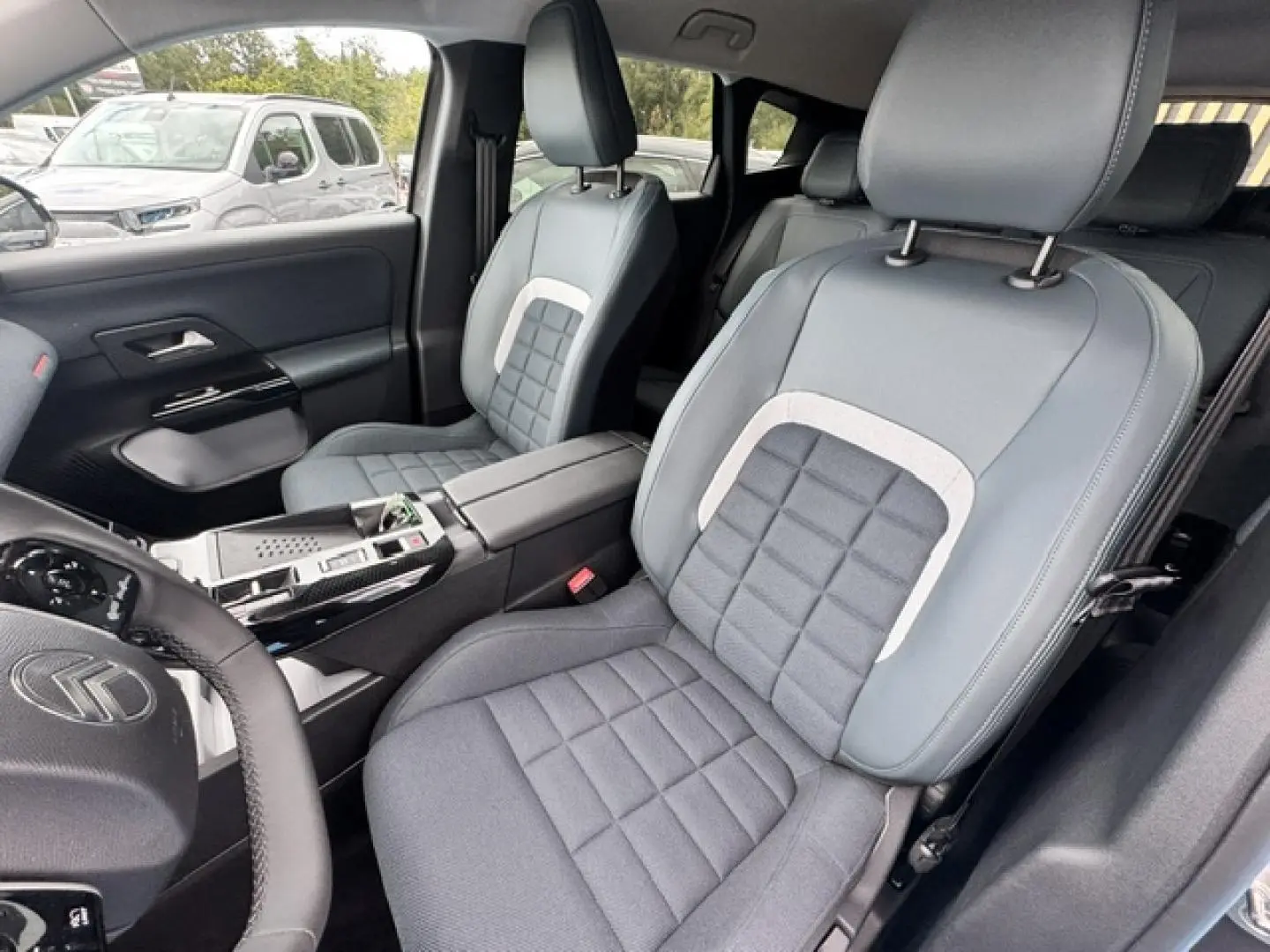 Vue intérieure côté conducteur du Citroën C5 Aircross 2026, sièges gris avec surpiqûres carrées et volant multifonction.